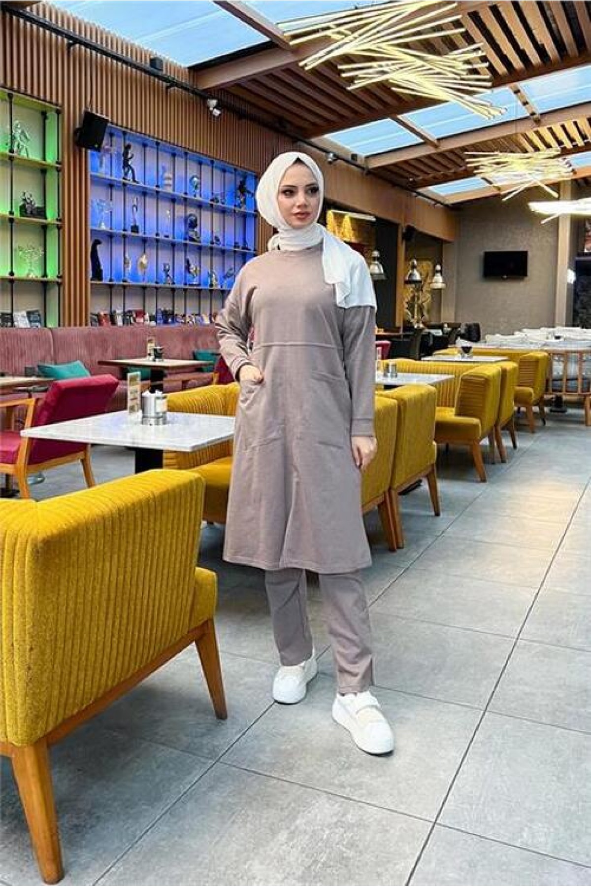 طقم رياضي بسيط مكون من قطعتين: بلوزة طويلة وبنطال، مع جيبين أماميين.