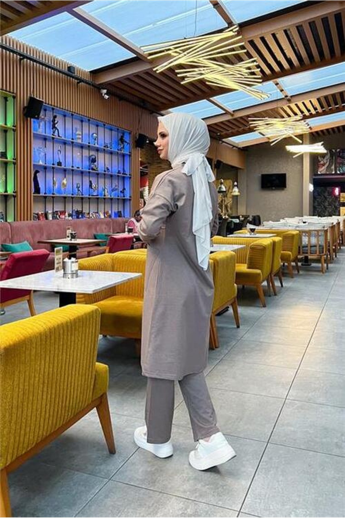 طقم رياضي بسيط مكون من قطعتين: بلوزة طويلة وبنطال، مع جيبين أماميين.