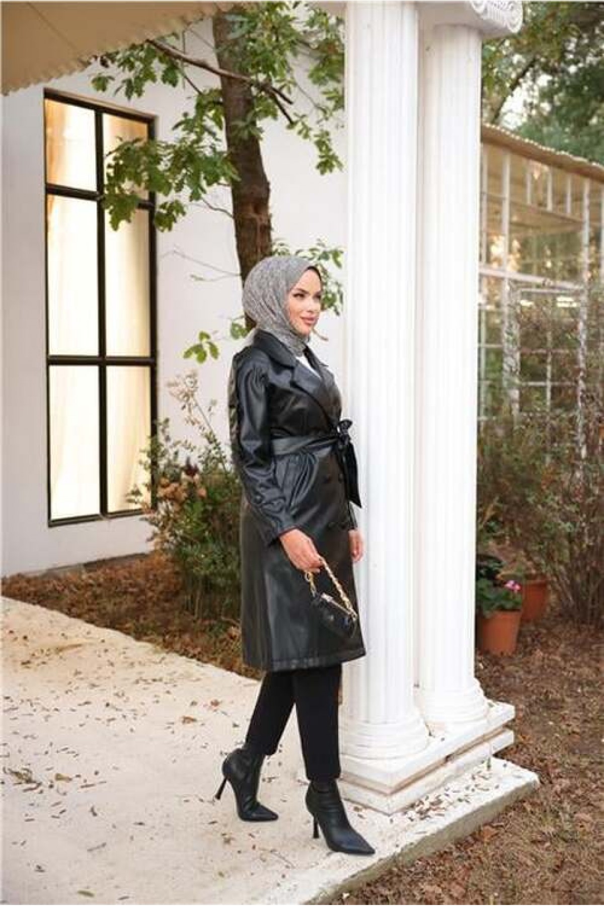 Double-breasted, pocketed, drawstring waist leather trench coat.