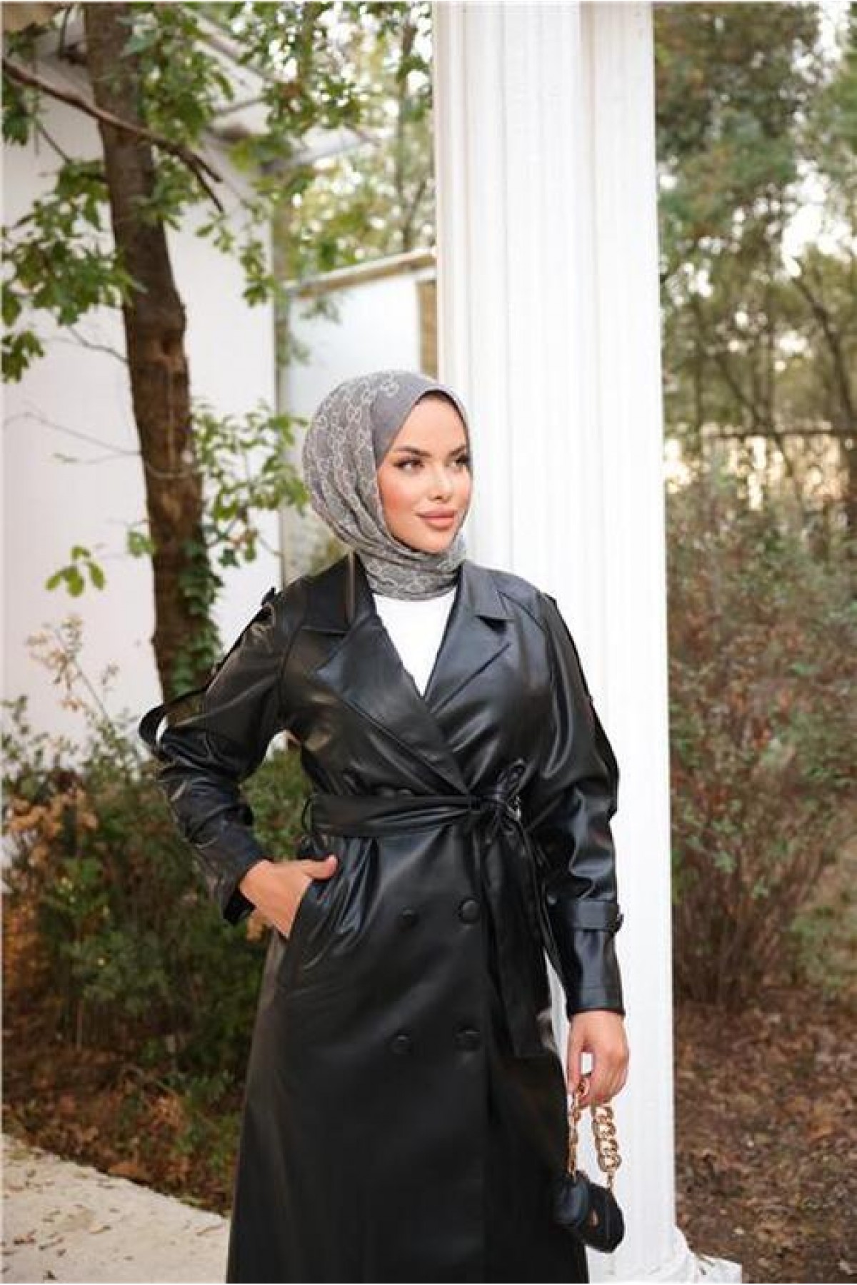 Double-breasted, pocketed, drawstring waist leather trench coat.