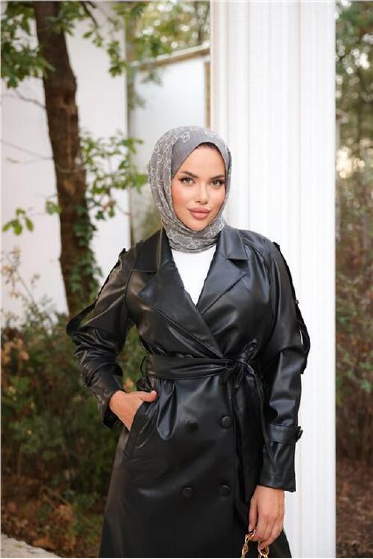 Double-breasted, pocketed, drawstring waist leather trench coat.