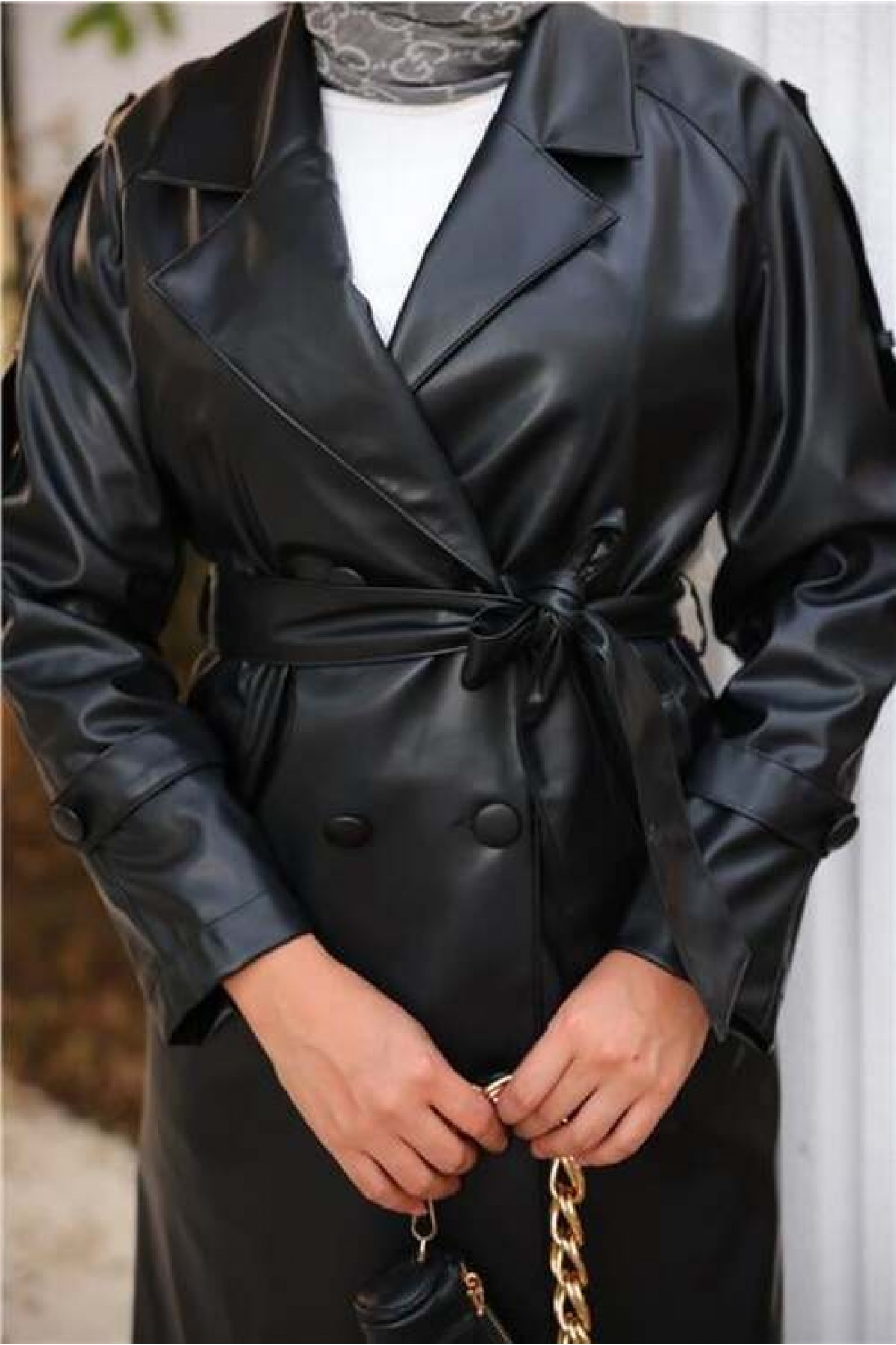 Double-breasted, pocketed, drawstring waist leather trench coat.