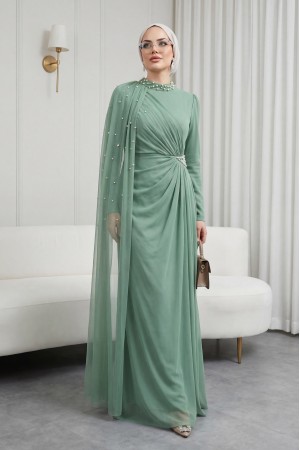 فستان سهرة بياقة عالية مزين باللؤلؤ وعباءة من التول. -كاجلا جرين