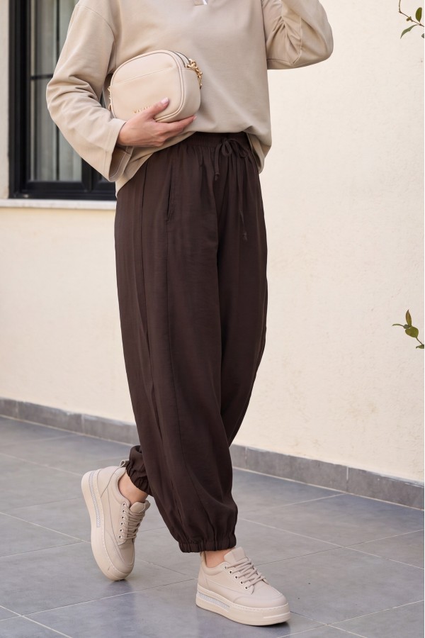 Modal trousers with elasticated waistband, pockets, and drawstring. -Brown