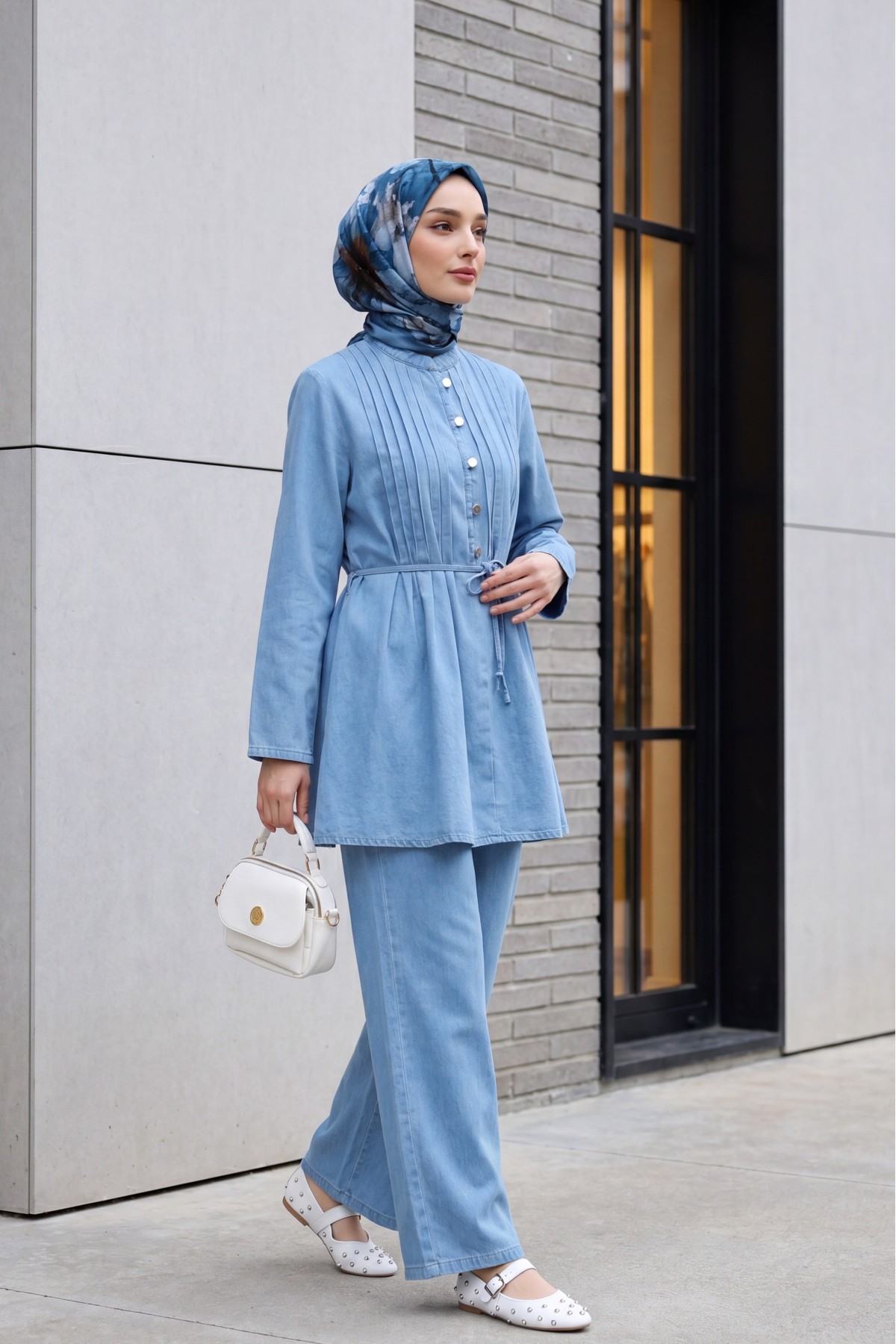 Half-buttoned, pleated front, tie-waist denim suit with trousers. -Light blue