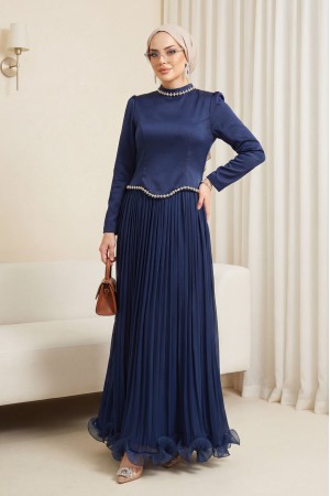 بلوزة من الساتان، وتنورة من الشيفون اللامع مزينة بتفاصيل من الأحجار والكشكشة. -كحلي